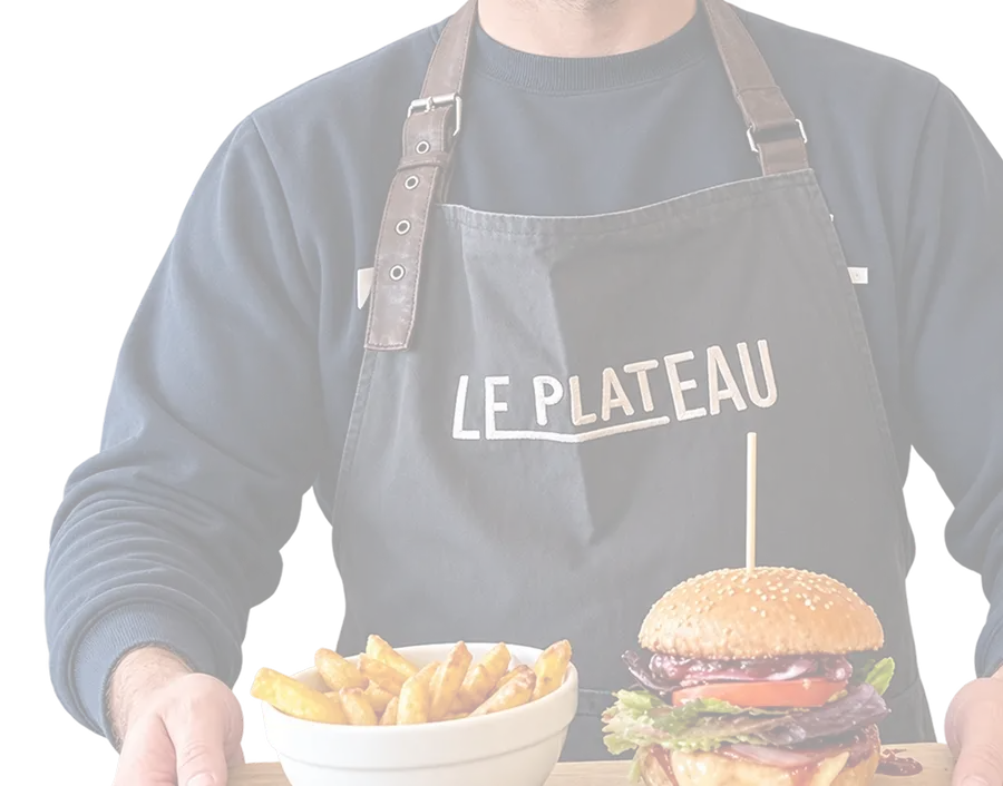 Un serveur du Bar Brasserie Le Plateau, tablier siglé, présente un burger maison et des frites sur une planche en bois